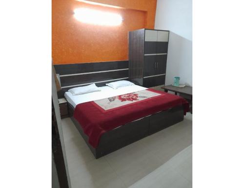 a bedroom with a large bed with a red blanket at Hotel Viren Sofitel, Agra in Agra