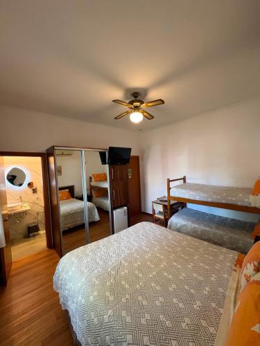 a bedroom with two beds and a ceiling fan at Hotel Argentina in Atlántida