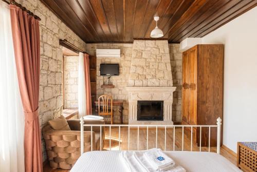 a bedroom with a stone wall with a fireplace at Alayaz Hotel in Alaçatı