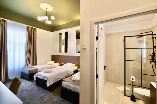 a hotel room with two beds and a bathroom at BOUL ROSU RESIDENCE free private parking in Arad