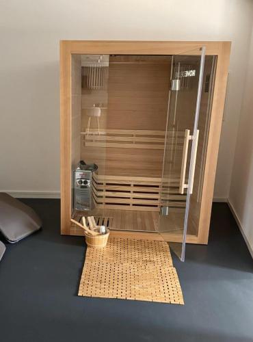 a wooden enclosure with a glass door on a floor at Hollender Hof in Bongard