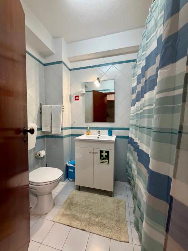 a bathroom with a toilet and a sink at Edificio Fragata A in Armação de Pêra