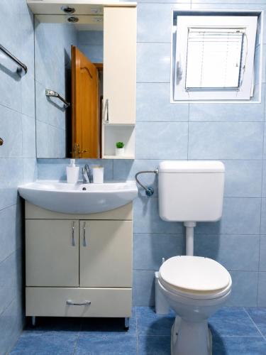 a bathroom with a white toilet and a sink at Викендица Братунац in Bratunac