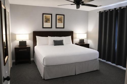 a bedroom with a large white bed with two lamps at Beau Rivage Golf and Resort in Myrtle Grove