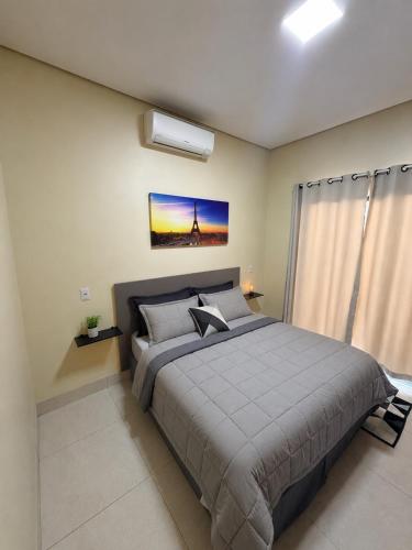 a bedroom with a large bed and a window at casa conforto e piscina in Sinop