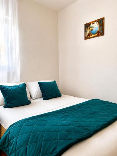 a bedroom with a bed with blue pillows on it at Викендица Братунац in Bratunac