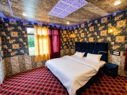 a bedroom with a bed in a room with pictures on the walls at Hotel GRITTI CASTLE in Wāmpor