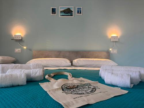 a room with a bed with a tote bag on it at B&B La Perla di Praia in Praia a Mare