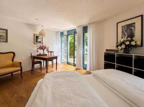a bedroom with a bed and a desk and a table at Boutique Garden Studio in Kreuzlingen