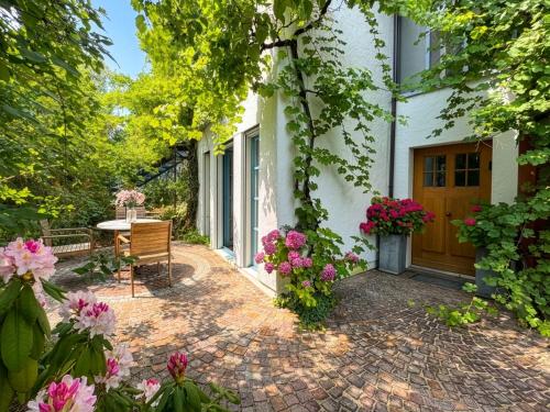 a patio with a table and flowers in front of a house at Boutique Garden Studio in Kreuzlingen
