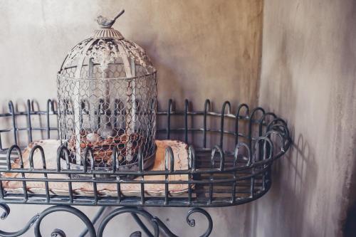 a bird cage hanging on a wall at Station House Simondium in Simondium