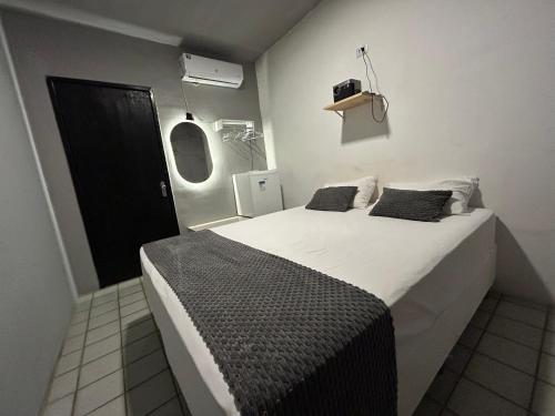 a bedroom with a large white bed and a black door at Suite Brisa da Colina in Garanhuns