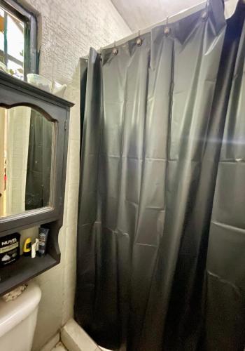 a bathroom with a shower with a black shower curtain at Cativa CozyHomestay in Hermosillo