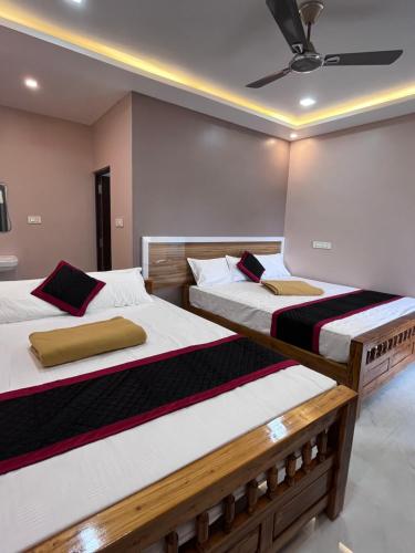 two twin beds in a room with a ceiling at VV Guest House & Rooms in Tiruvannāmalai