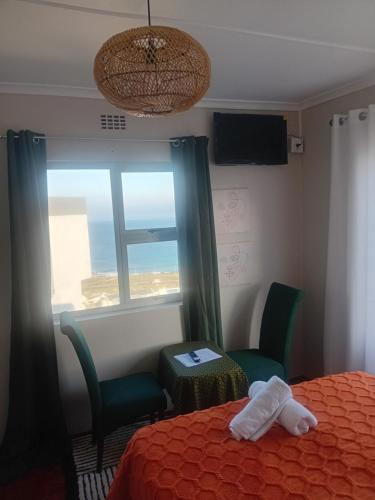 a room with a bed and two chairs and a window at Oasis Simon's town cape town in Glencairn