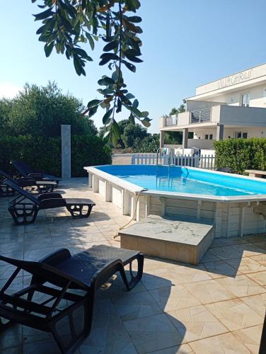 a swimming pool with two chairs and a table at Villa Chirilú in Polignano a Mare