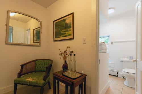 a bathroom with a chair and a table and a mirror at The Woodbine Inn in Palenville