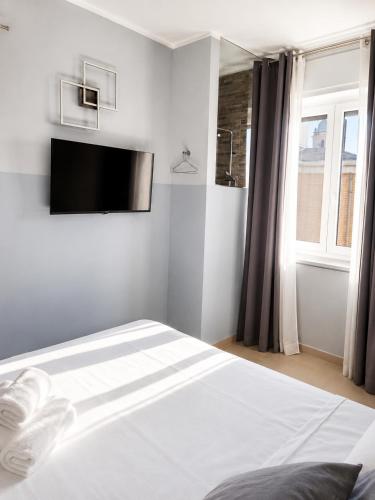 a bedroom with a bed with a tv on the wall at Suite Panoramica - Novara Centro in Novara