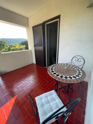 a patio with a table and chairs on a floor at Holiday House Bribir in Bribir
