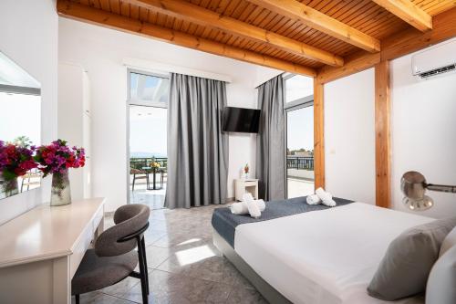 a bedroom with a large white bed and a desk at Stella Maris in Kos