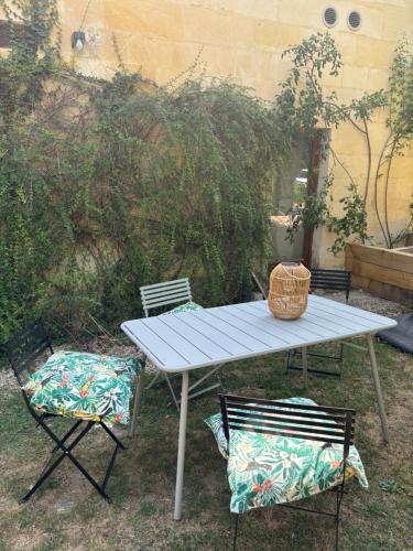 a picnic table with two chairs and a basket on it at Cyprès des Vignes- L'Ecrin in Hermonville