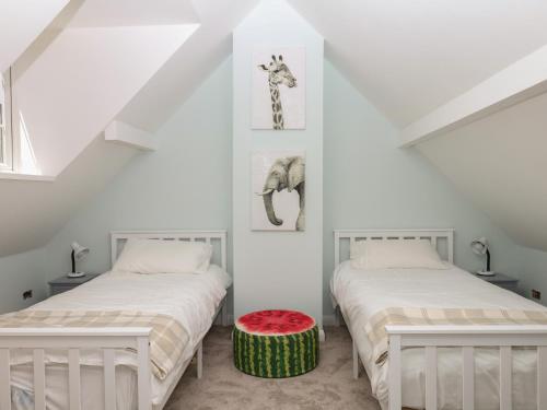 two beds in a room with white walls at The White House in Okehampton