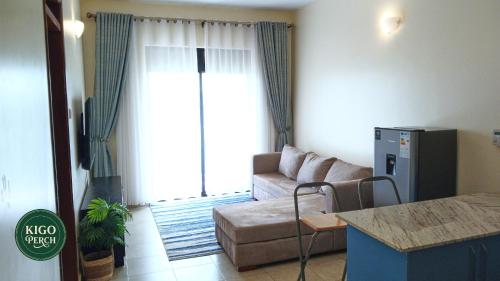 a living room with a couch and a table at Kigo Perch in Kampala