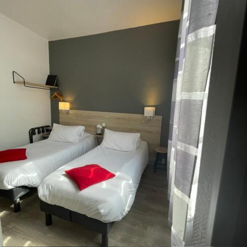 ein Hotelzimmer mit zwei Betten mit roter Bettwäsche in der Unterkunft Hôtel Le Picardy in Saint-Dizier