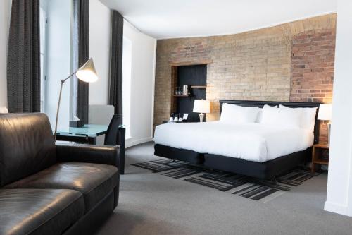 a hotel room with a bed and a couch at Hotel Le Saint-Paul in Quebec City