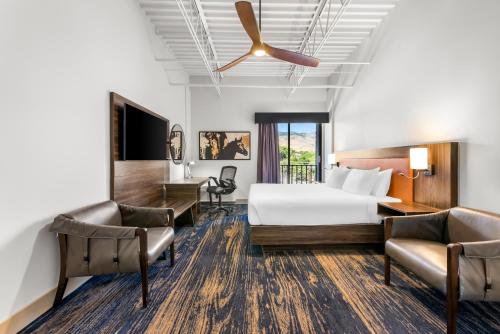 a hotel room with a bed and two chairs at The Federal Hotel Downtown Carson City, an Ascend Collection Hotel in Carson City