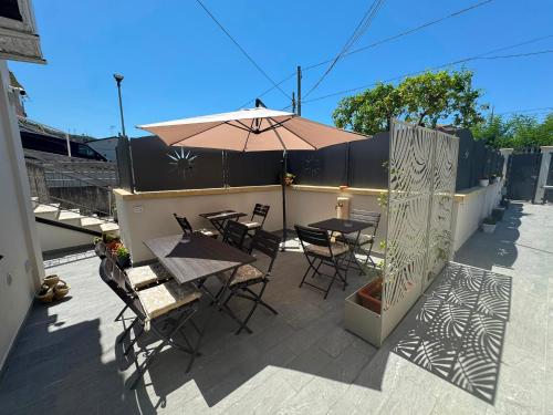a patio with tables and chairs and an umbrella at B&B La Perla di Praia in Praia a Mare