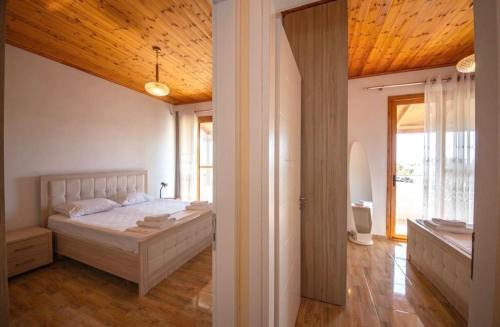 a bedroom with a bed with a wooden ceiling at Golden Berden Boutique Apart-Hotel in Sarandë