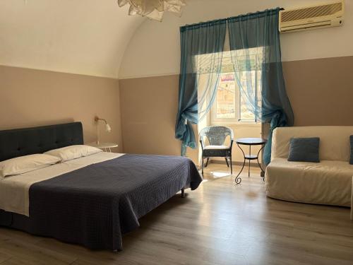 a bedroom with a bed and a chair and a window at I Tetti di Siciliando in Modica