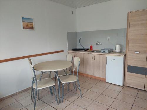 a small kitchen with a table and chairs in it at Domki letniskowe Reda in Rusinowo