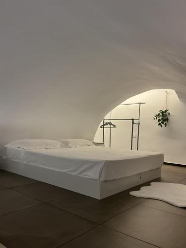 a white bed in a white room with a white wall at Moira Luxury Appartament in Bitonto