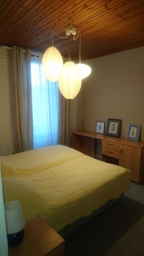 a bedroom with a yellow bed and two lights at RTV Central in Ljubljana