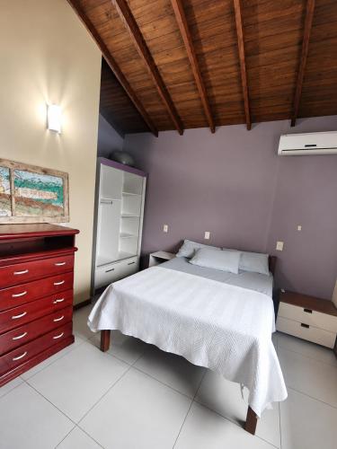 a bedroom with a white bed and a wooden ceiling at O melhor de Garopaba in Garopaba