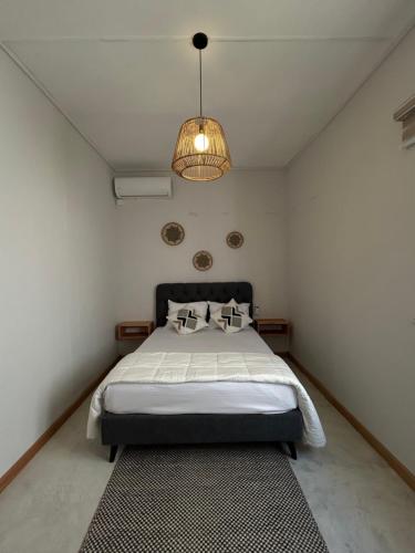 a bedroom with a bed and a pendant light at Alizé Mont Choisy in Mont Choisy