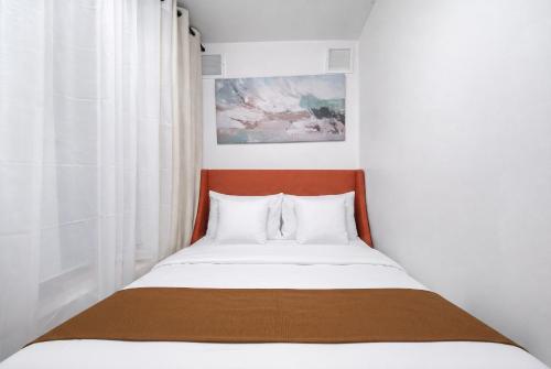 a bedroom with a bed with white sheets and white pillows at Cozy 4BD Unit in Lower Manhattan in New York