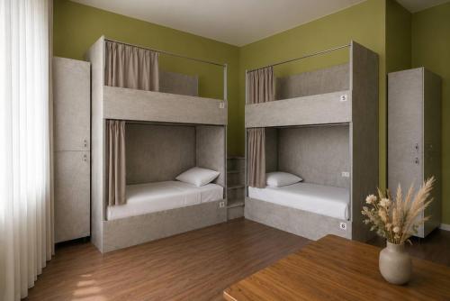 two bunk beds in a room with a table at Nomad Aktau Hostel in Aktau