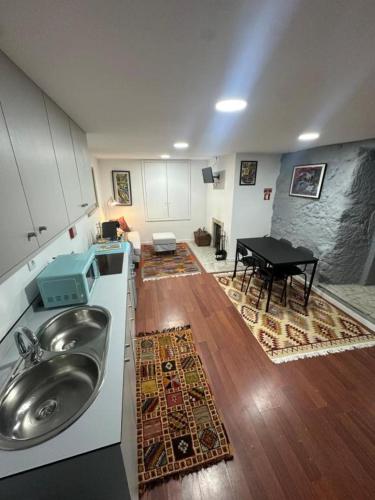 a kitchen with a sink and a table in a room at Casa do Apeadeiro in Vila Pouca de Aguiar