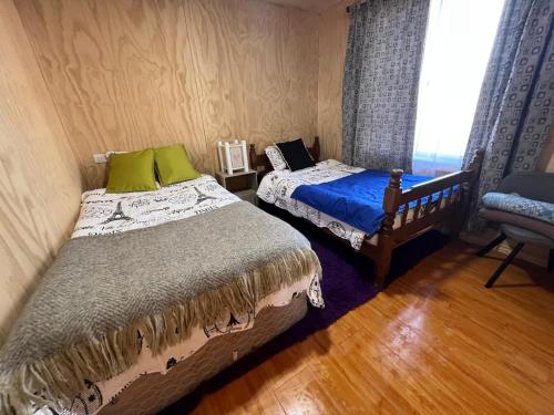 a bedroom with two beds and a window at CasasAnique in Cañete