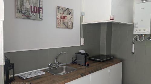 a kitchen with a sink and a counter top at Vasco Santana Guesthouse in Odivelas