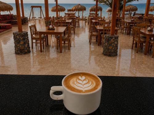 a cup of coffee sitting on a table in a restaurant at Mermaid camp in Nuweiba