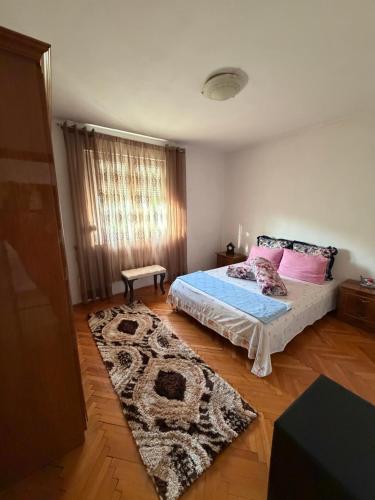 a bedroom with a bed and a rug at Apartman Damir in Čeluga