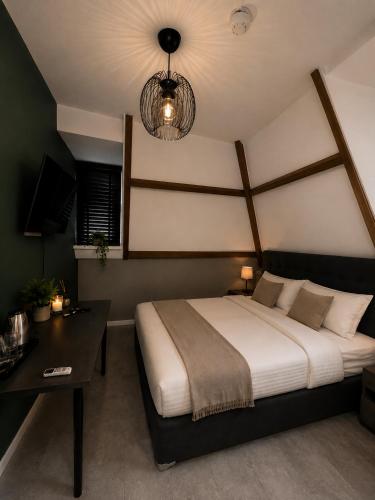 a bedroom with a large bed and a table at Boutique Hotel Mare in Middelburg