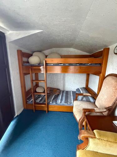 a small room with a bunk bed and a chair at Britania Hobbit in Predeluţ