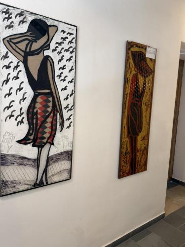 two paintings of a woman on a wall at Rifugio Escursionistico Locanda Borgo Villa in Acceglio