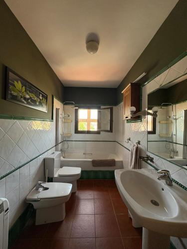 a bathroom with two sinks and a toilet and a tub at Casa Nectarius in Cifuentes