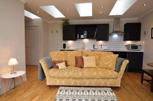 a living room with a couch and a kitchen at Cuil Steading in Cairndow
